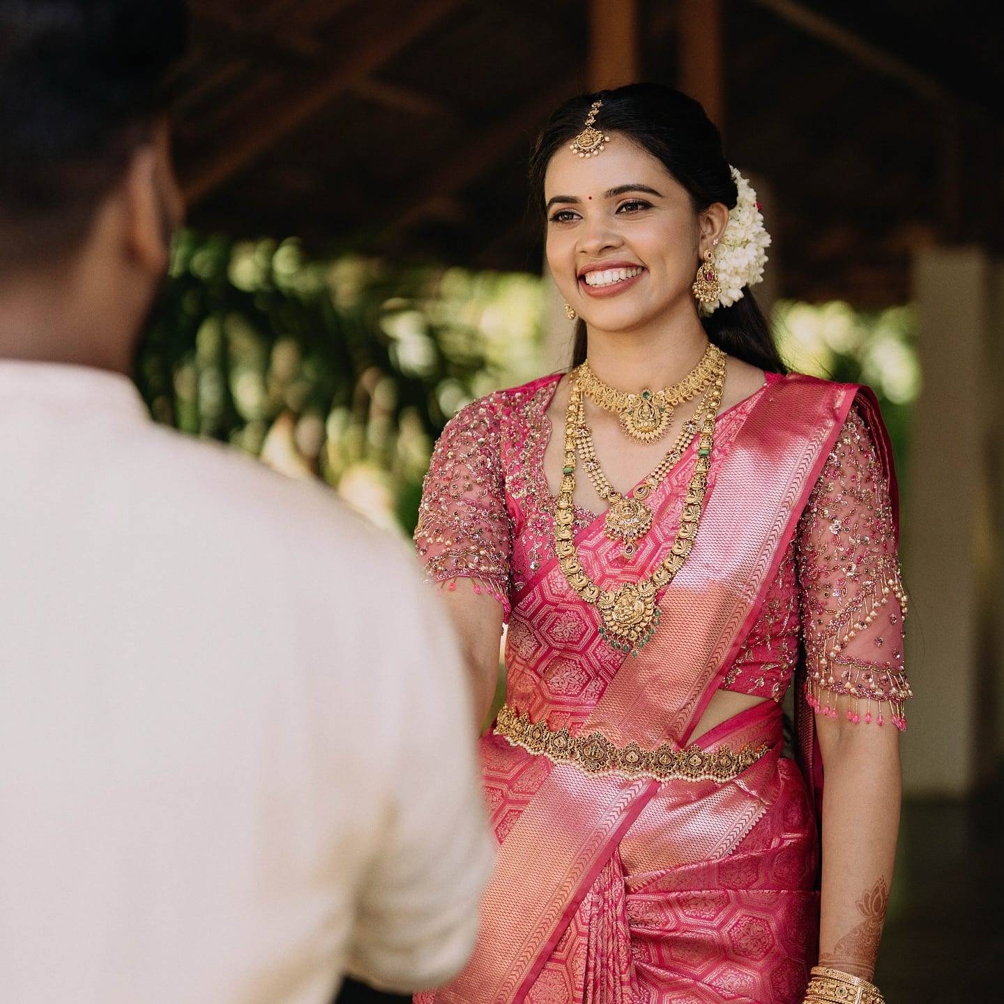 Real bride in a rani-pink silk saree with a hand-embroidered blouse