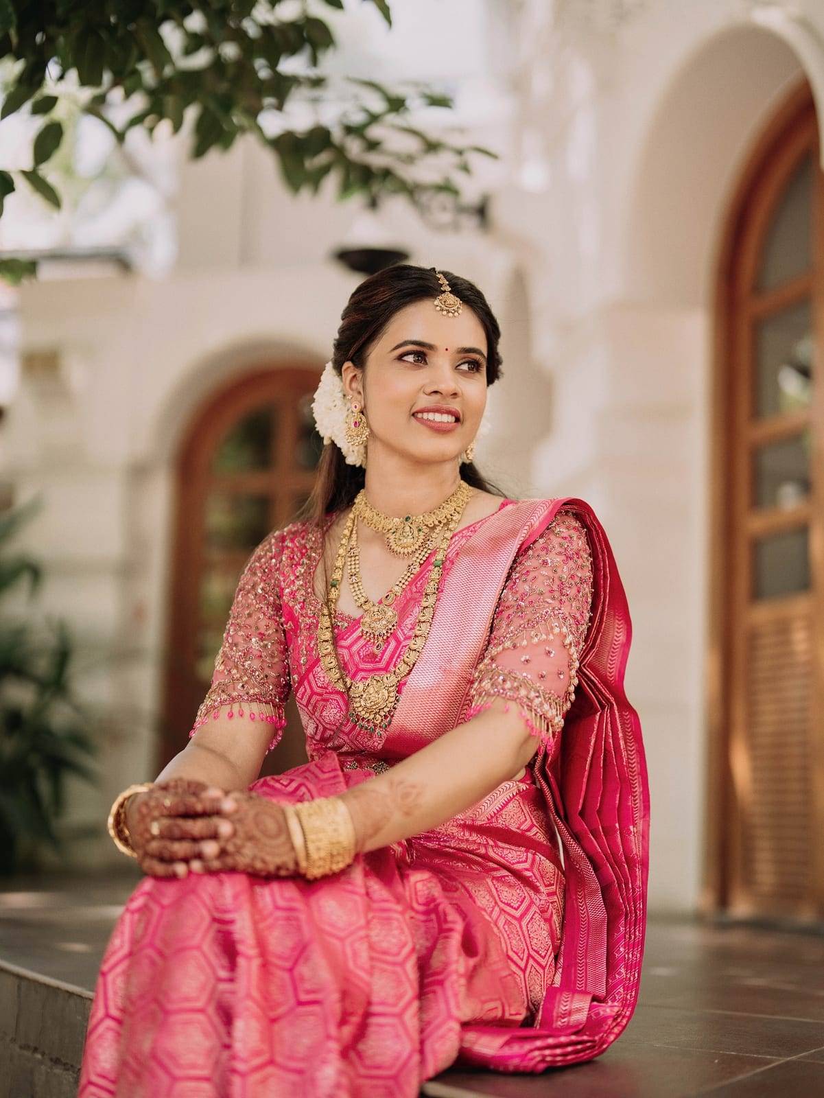 Real bride in a rani-pink silk saree with a hand-embroidered blouse