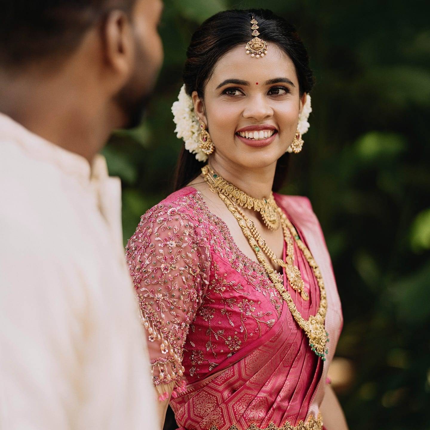 Real bride in a rani-pink silk saree with a hand-embroidered blouse